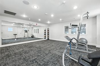 A gym with a grey carpet and white walls.